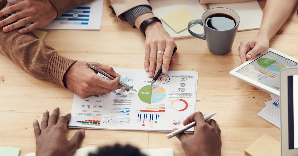 Equipe analisando graficos sobre uma mesa