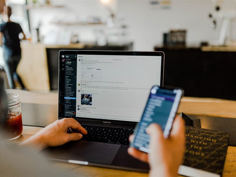 Empreendedor usando notebook e celular para gerenciar o financeiro da empresa